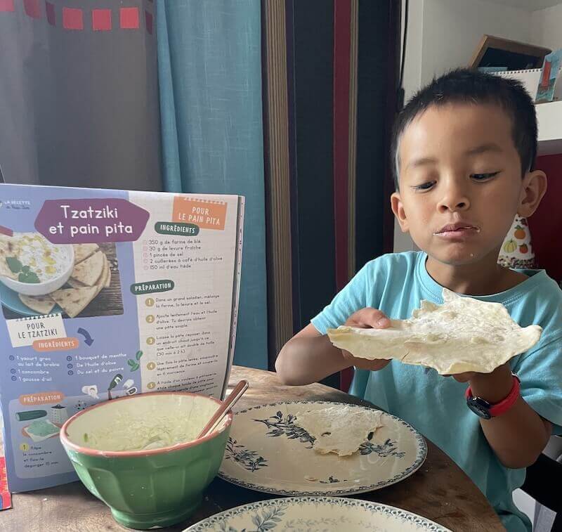 Tom déguste son pain pita qu'il a réalisé grâce à la recette de son magazine Les Mini Mondes