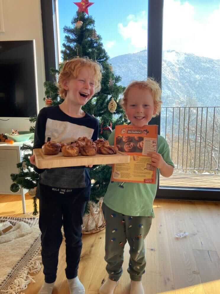Deux enfants avec le magazine les mini mondes ayant fait une recette du magazine et tenant leurs pâtisseries réalisées.