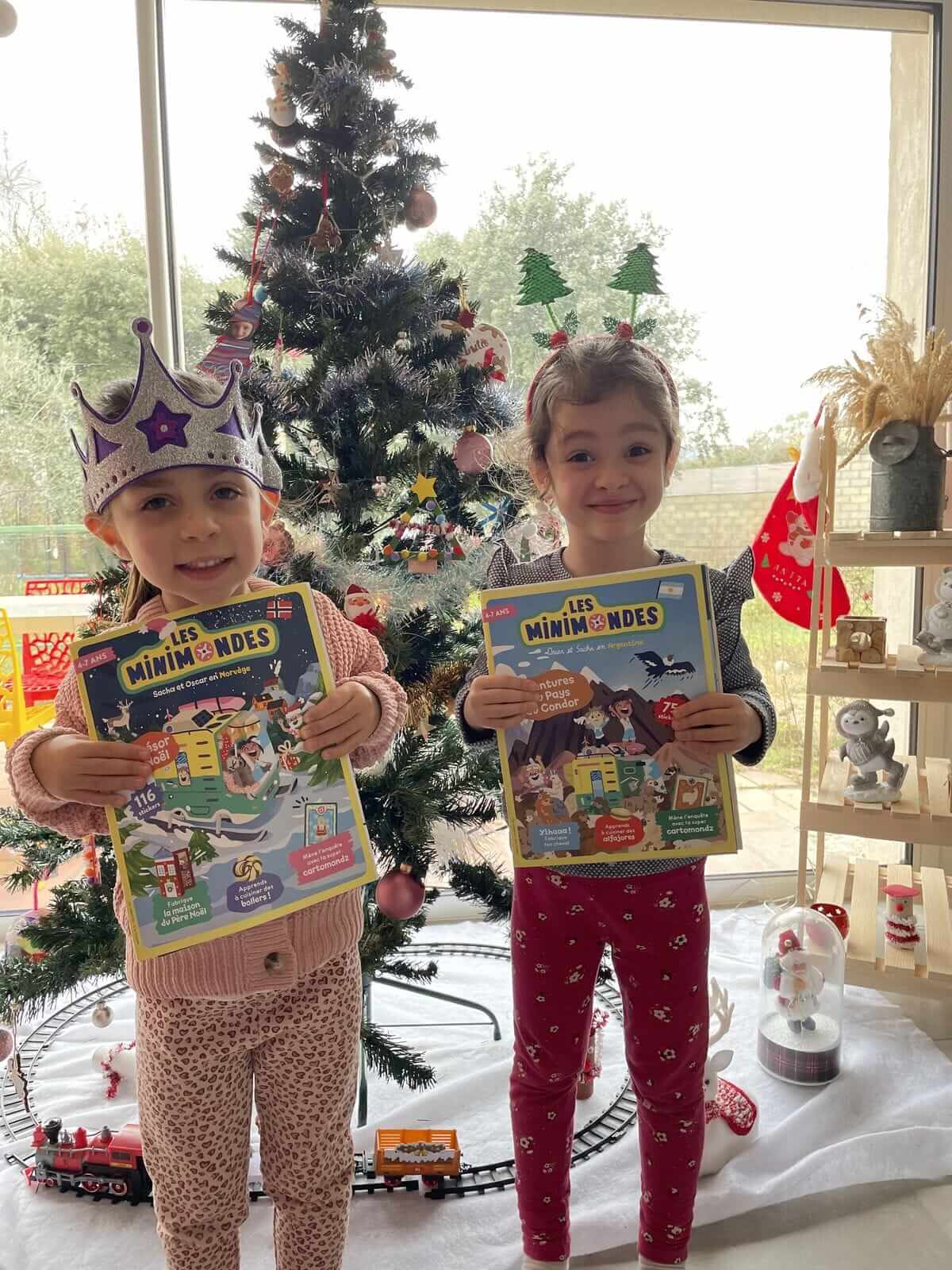 Deux abonnées qui posent devant leur sapin de noël avec leurs magazines Les Mini Mondes