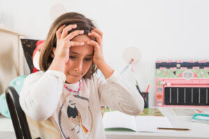 Fille frustrée pendant ses devoirs, montrant un danger de l'éducation positive sans cadre.